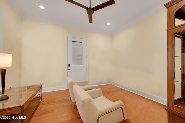 sitting room featuring ceiling fan, ornamental molding, and light hardwood / wood-style flooring