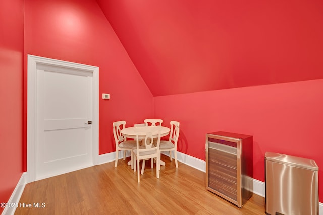 dining space featuring vaulted ceiling, hardwood / wood-style floors, and wine cooler