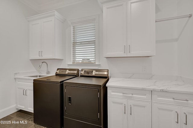 washroom featuring cabinets, crown molding, sink, and washer and clothes dryer