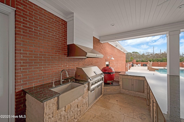 view of patio with an outdoor kitchen, grilling area, a fenced in pool, and sink