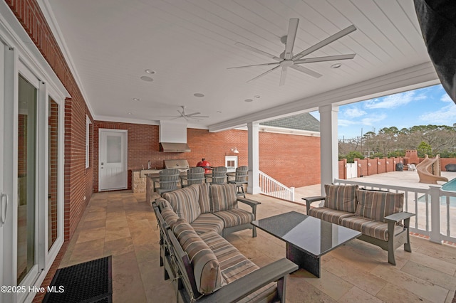 view of patio featuring ceiling fan, an outdoor living space, and exterior kitchen