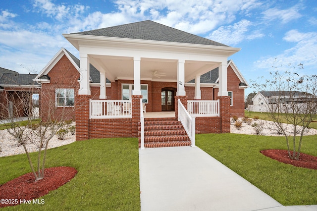 view of front of house featuring a front yard, ceiling fan, and covered porch