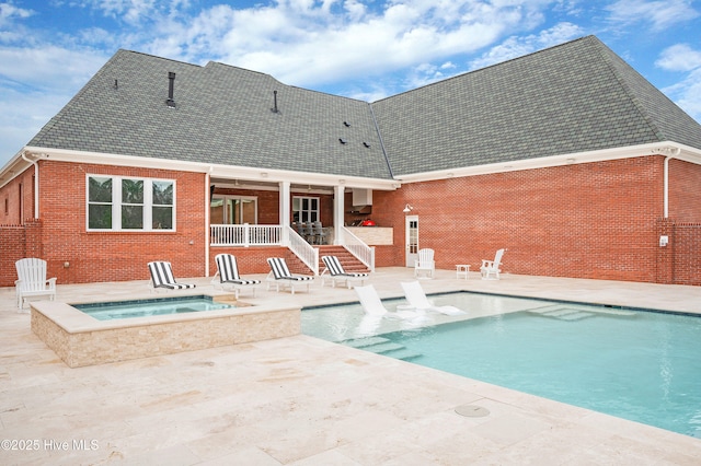 view of swimming pool with a patio and an in ground hot tub