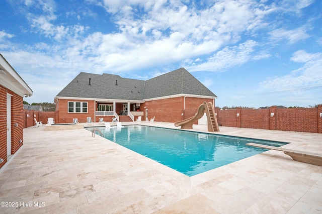 view of swimming pool with a patio area and a water slide