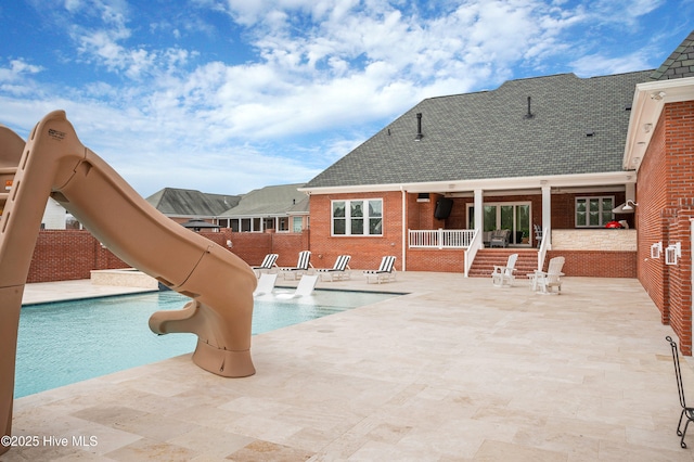 view of pool with a patio area and a water slide