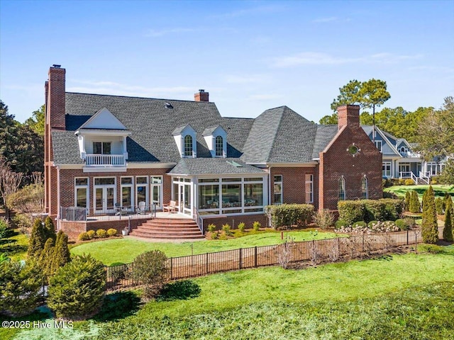 rear view of house with a fenced backyard, a chimney, and a balcony