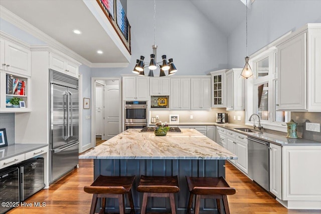 4174 Brookfield Way, Southport, NC 28461 - kitchen with appliances with stainless steel finishes, a sink, a breakfast bar, high vaulted ceiling, and a chandelier