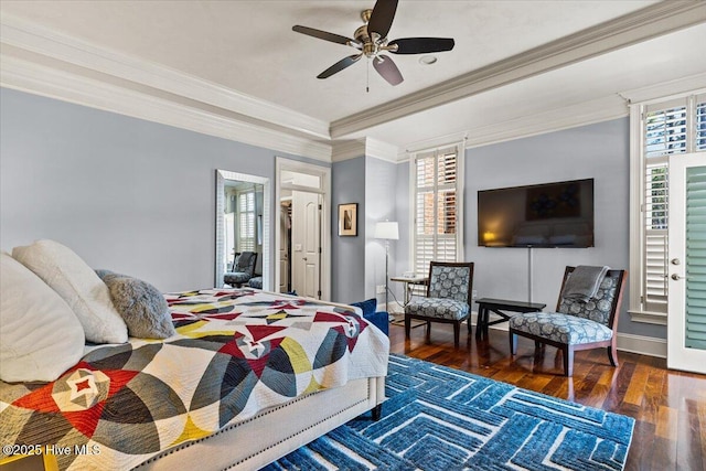bedroom with ceiling fan, crown molding, wood finished floors, a raised ceiling, and baseboards