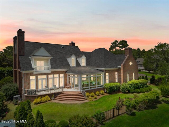 4174 Brookfield Way, Southport, NC 28461 - back of property at dusk featuring a balcony, french doors, and brick siding