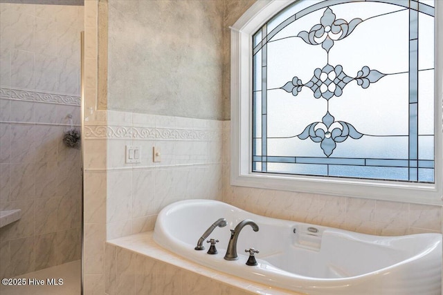 bathroom with walk in shower and a bath