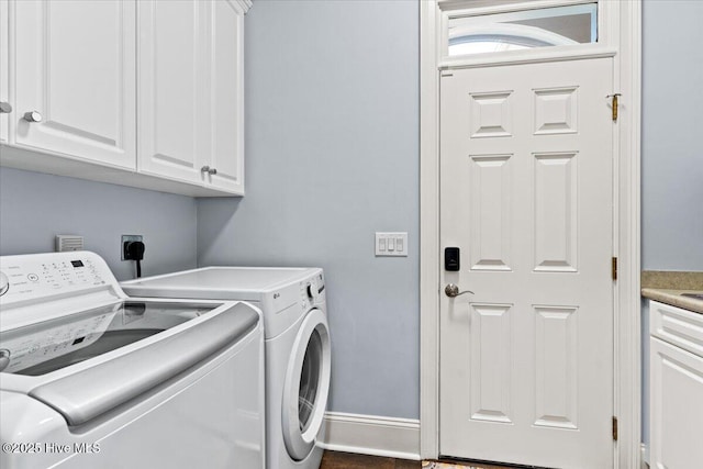 washroom featuring baseboards, cabinet space, and washer and dryer