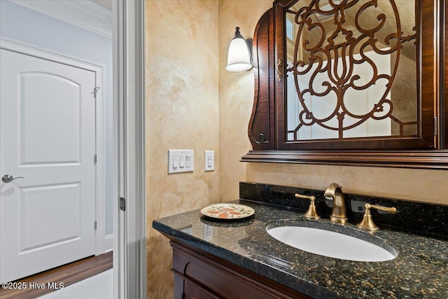 bathroom featuring vanity, ornamental molding, and a textured wall