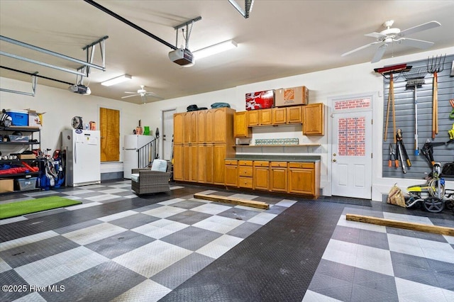 garage featuring ceiling fan, freestanding refrigerator, and a garage door opener