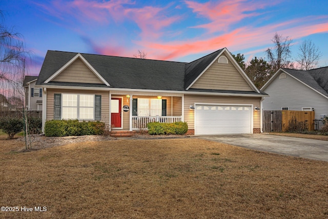 view of front of home with a garage, a lawn, and covered porch