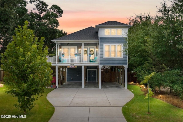 view of front of house with a carport, a yard, ceiling fan, and french doors