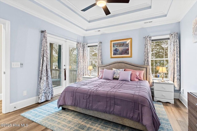 122 NW 19th St, Oak Island, NC 28465 - bedroom with wood finished floors, visible vents, access to outside, and a raised ceiling