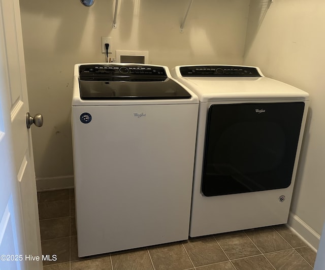 laundry area with dark tile patterned flooring and independent washer and dryer