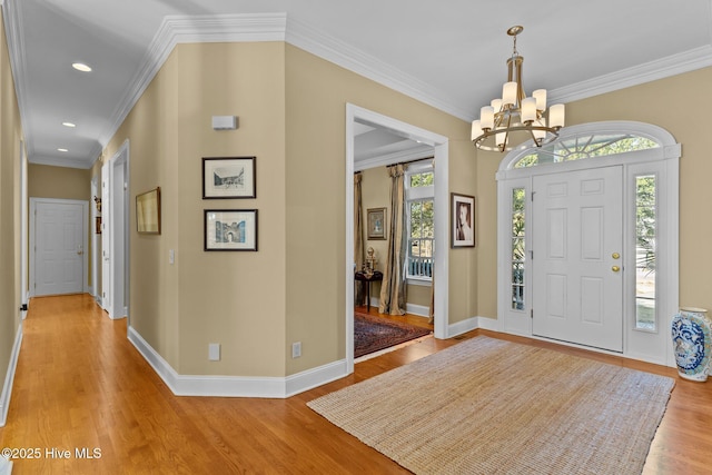 foyer featuring crown molding, a chandelier, and light hardwood / wood-style floors