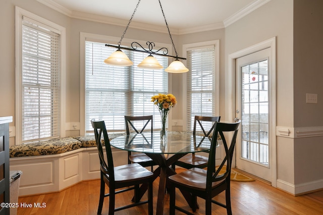 dining room with crown molding, a wealth of natural light, and light wood-type flooring