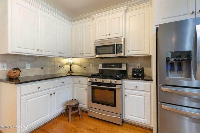 kitchen featuring stainless steel appliances, tasteful backsplash, white cabinets, and light hardwood / wood-style floors