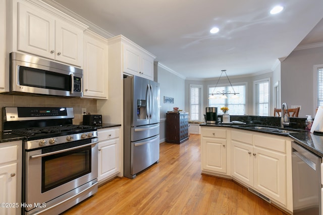 kitchen with sink, crown molding, light wood-type flooring, appliances with stainless steel finishes, and white cabinets