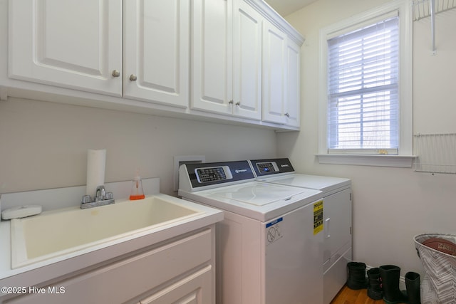 washroom featuring sink, washer and clothes dryer, and cabinets