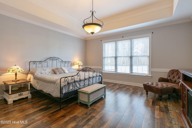 bedroom with dark hardwood / wood-style flooring, crown molding, and a raised ceiling