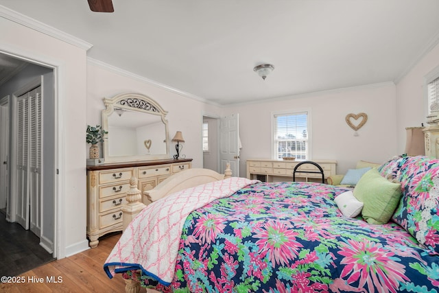 bedroom featuring ornamental molding, light wood-type flooring, ceiling fan, and baseboards