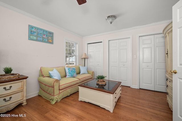 living room featuring ornamental molding, baseboards, and wood finished floors