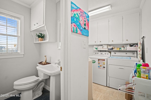 washroom with laundry area, light tile patterned floors, baseboards, washer and clothes dryer, and ornamental molding