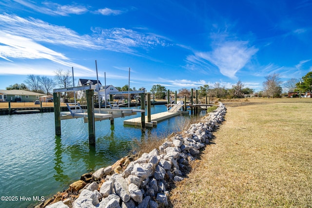 dock area with a lawn, a water view, and boat lift