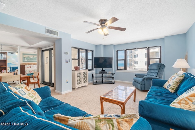 living room featuring visible vents, ceiling fan, light carpet, and baseboards