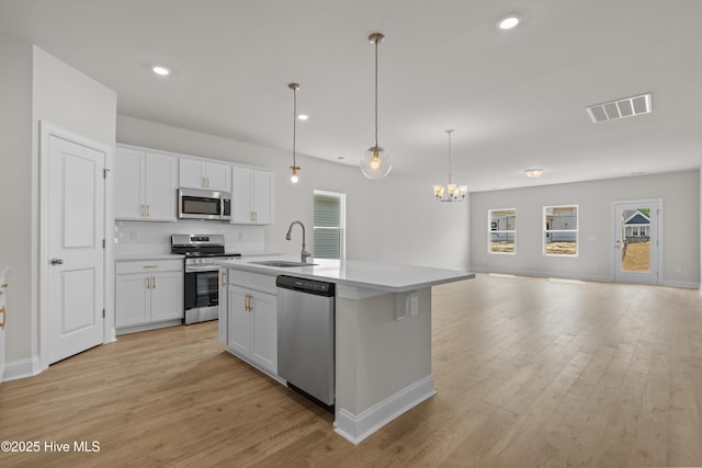1200 Calabash Station Blvd NW, Calabash, NC 28467 - kitchen with stainless steel appliances, a sink, open floor plan, a chandelier, and white cabinets