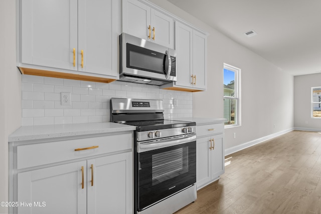 1200 Calabash Station Blvd NW, Calabash, NC 28467 - kitchen featuring stainless steel appliances, backsplash, white cabinets, and light wood-type flooring