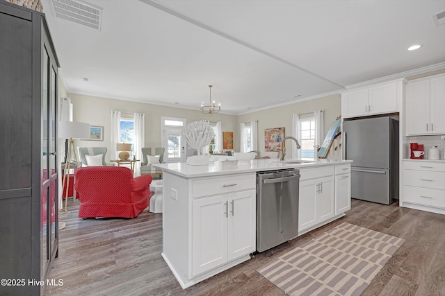 kitchen with appliances with stainless steel finishes, sink, a center island with sink, and white cabinets