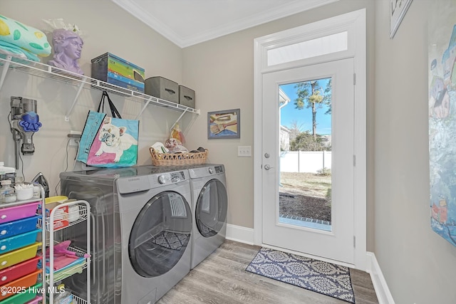 washroom with independent washer and dryer, ornamental molding, and light hardwood / wood-style floors