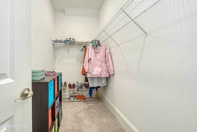 walk in closet featuring light carpet