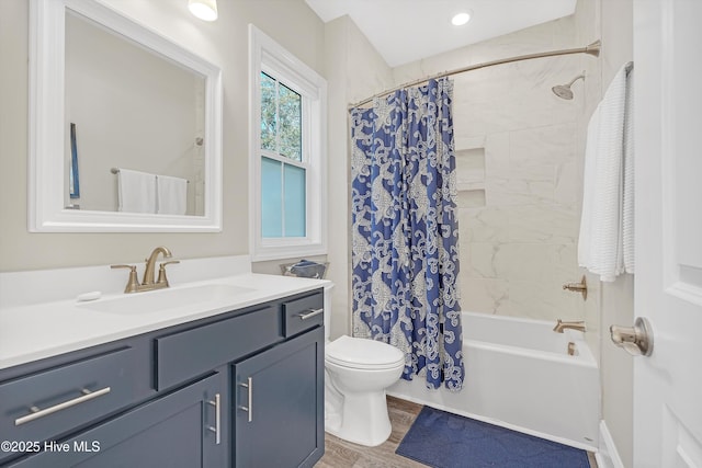 full bathroom featuring vanity, hardwood / wood-style floors, shower / bathtub combination with curtain, and toilet