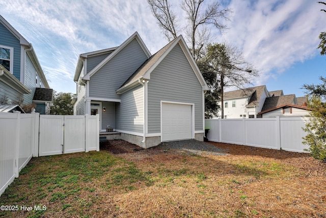 view of side of property with a garage and a lawn