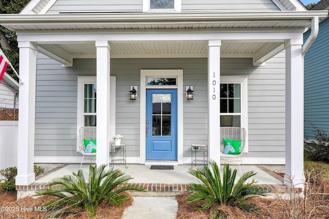 view of exterior entry featuring covered porch