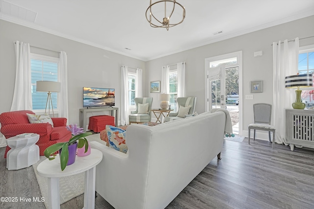 living room featuring crown molding, a notable chandelier, and dark hardwood / wood-style flooring