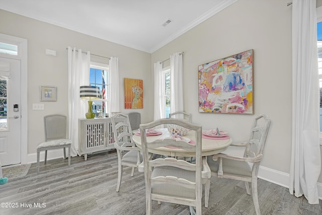 dining room with hardwood / wood-style flooring and ornamental molding