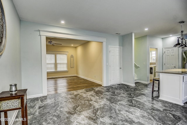 living room featuring washer / clothes dryer, plenty of natural light, and ceiling fan