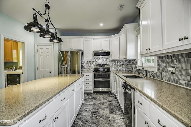 kitchen featuring sink, stainless steel appliances, independent washer and dryer, and white cabinets