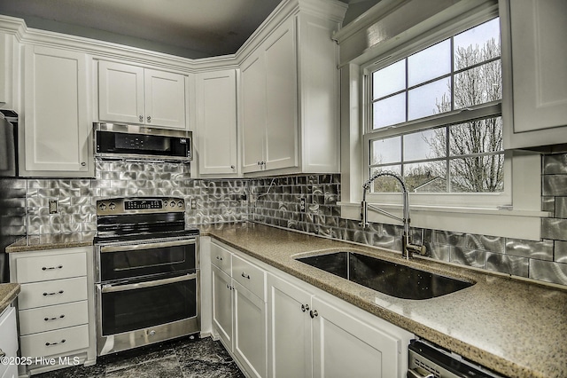 kitchen featuring stainless steel appliances, white cabinetry, and sink