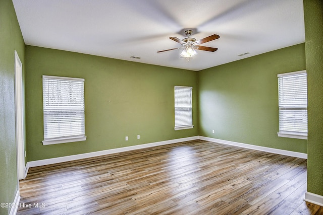 spare room with ceiling fan and light wood-type flooring