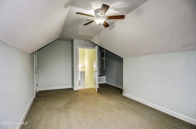 bonus room featuring ceiling fan, lofted ceiling, carpet, and a textured ceiling