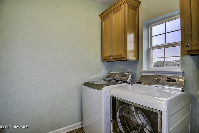 washroom featuring cabinets and washing machine and clothes dryer