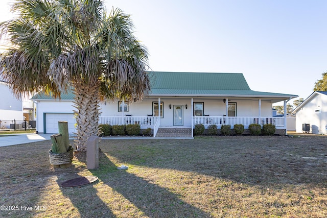 view of front of home featuring a garage, covered porch, and a front lawn