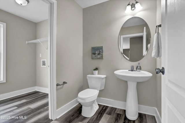 bathroom with hardwood / wood-style floors, sink, and toilet